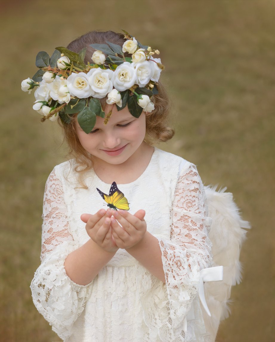 Little Girl Dressed as an Angel With a Butterfly in Her Hands